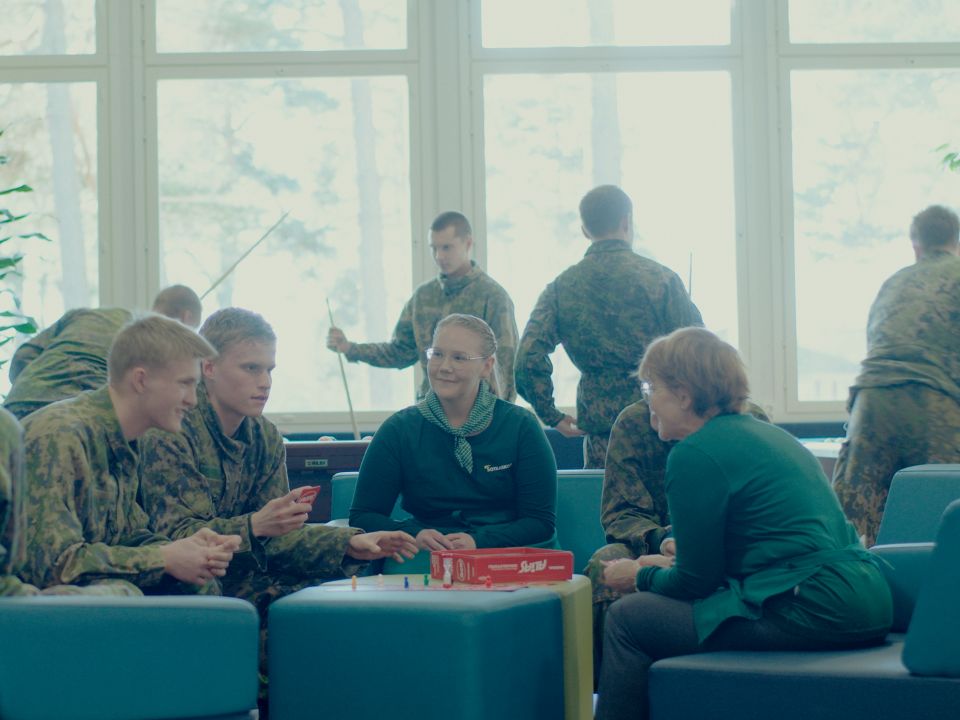 Upinniemen sotilaskodissa varusmiehet ja sotilaskotisisaret pelaavat lautapelejä.
