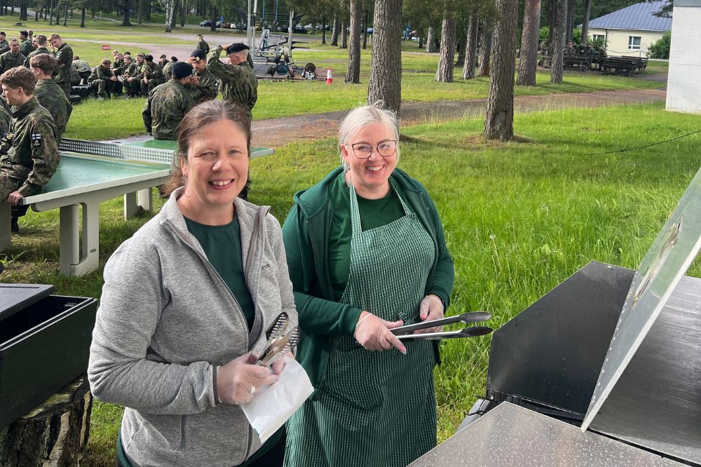 Sotilaskotisisaret grillaamassa makkaraa Upinniemen sotilaskodin pihalla varusmiesten kotitusjuhlissa.
